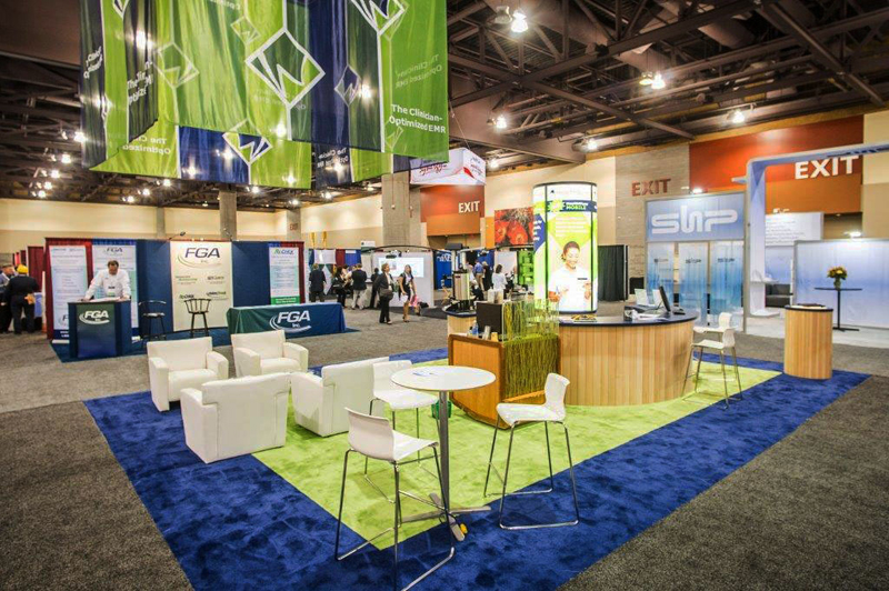 HealthWyse’s island custom exhibit with circular counter, built-in storage, light box, monitor, seating areas, and laptop stations