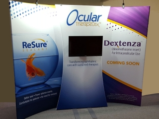 Ocular Therapeutix 10x10 curved portable fabric display with bold graphics, lighting and center fabric monitor stand