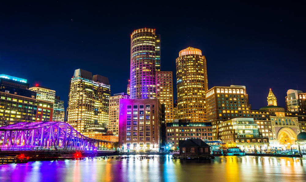 The Boston skyline and Fort Point Channel at night from Fan Pier Park